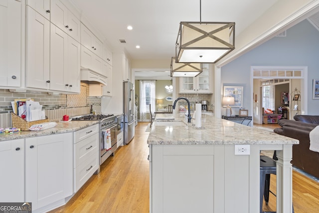 572 Austin Rd, Newnan, GA 30263 - kitchen with high end appliances, a sink, open floor plan, tasteful backsplash, and white cabinets