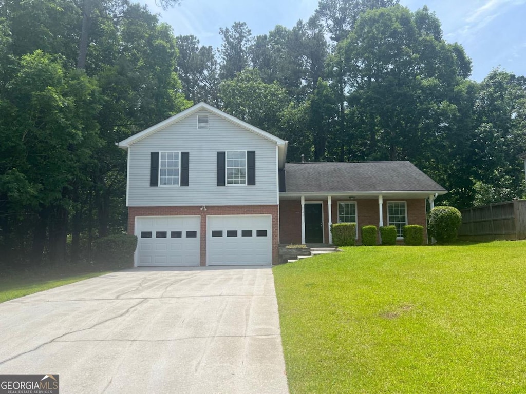 6541 Lazy Creek Ct, Lithonia, GA 30058 - tri-level home with concrete driveway, covered porch, brick siding, and a garage