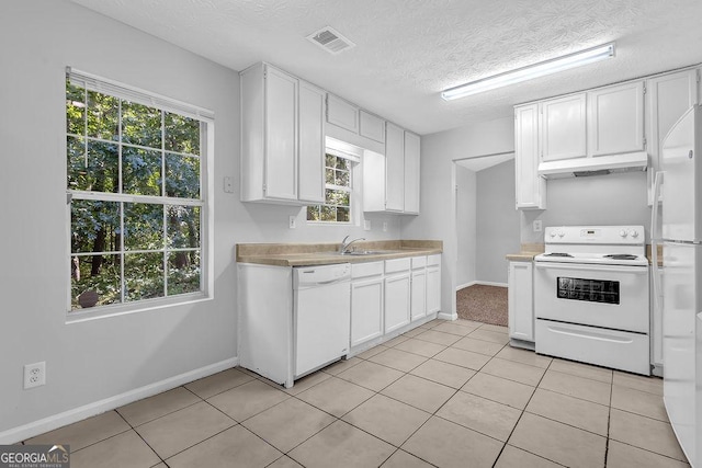6541 Lazy Creek Ct, Lithonia, GA 30058 - kitchen with white appliances, under cabinet range hood, light countertops, white cabinets, and baseboards