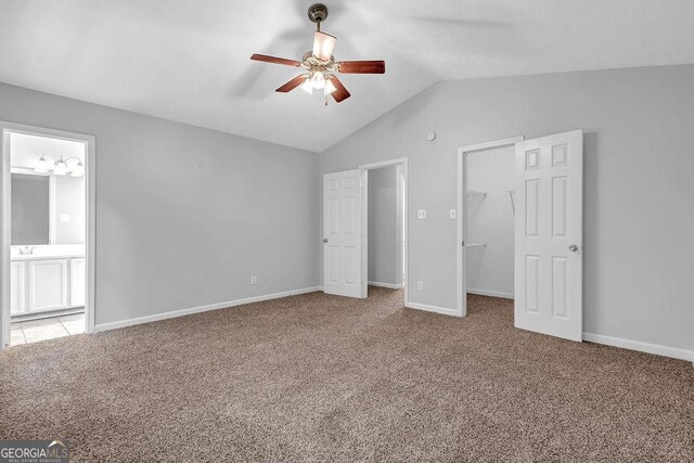 6541 Lazy Creek Ct, Lithonia, GA 30058 - unfurnished bedroom with carpet, a walk in closet, vaulted ceiling, connected bathroom, and a closet
