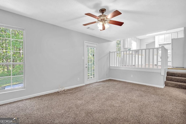 6541 Lazy Creek Ct, Lithonia, GA 30058 - carpeted empty room with a ceiling fan, baseboards, and stairs