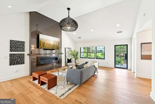 1815 Coventry Rd, Decatur, GA 30030 - living room with high vaulted ceiling, wood finished floors, a glass covered fireplace, baseboards, and recessed lighting