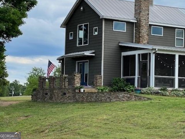 135 Horseshoe Trl, Commerce, GA 30529 - view of front facade featuring a chimney, a sunroom, a front yard, and metal roof