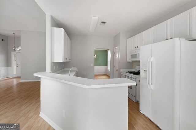 4801 Devonhurst Way, Powder Springs, GA 30127 - kitchen with white appliances, light wood-style floors, white cabinets, light countertops, and a peninsula