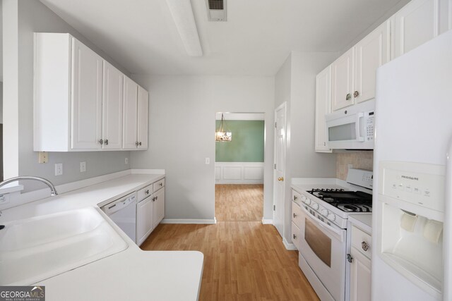 4801 Devonhurst Way, Powder Springs, GA 30127 - kitchen with white appliances, a sink, light wood finished floors, white cabinets, and tasteful backsplash