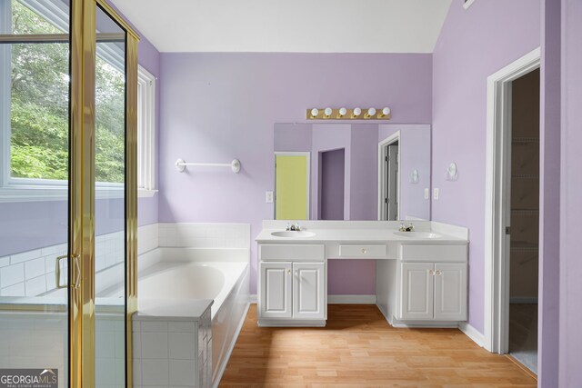 4801 Devonhurst Way, Powder Springs, GA 30127 - bathroom featuring double vanity, a bath, wood finished floors, and a stall shower