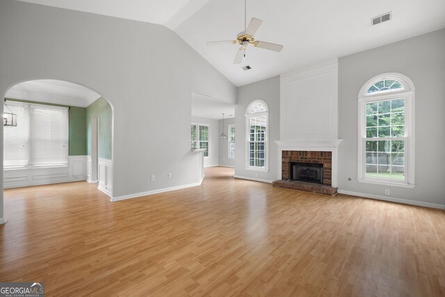 4801 Devonhurst Way, Powder Springs, GA 30127 - unfurnished living room featuring light wood-style flooring, ceiling fan, a brick fireplace, high vaulted ceiling, and arched walkways