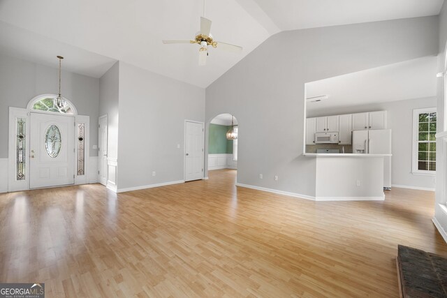 4801 Devonhurst Way, Powder Springs, GA 30127 - unfurnished living room with high vaulted ceiling, a ceiling fan, light wood-type flooring, arched walkways, and baseboards