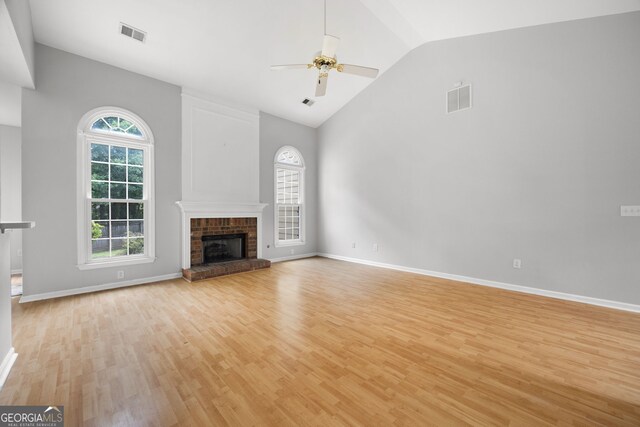 4801 Devonhurst Way, Powder Springs, GA 30127 - unfurnished living room with light wood finished floors, plenty of natural light, a ceiling fan, a brick fireplace, and high vaulted ceiling