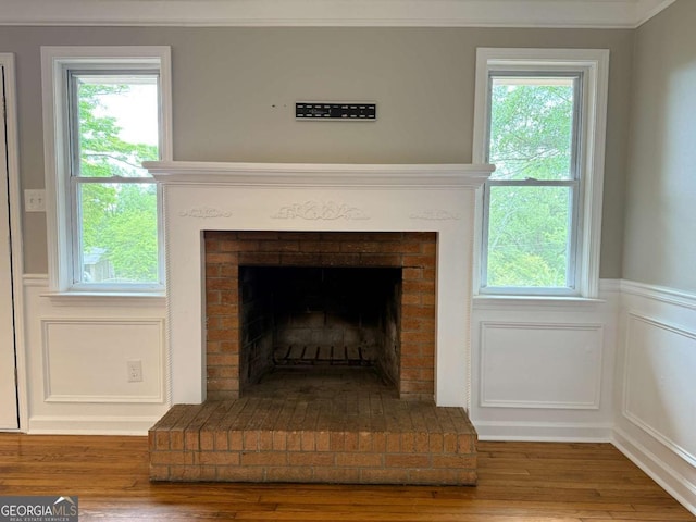 2751 Wayman Dr, Gainesville, GA 30506 - detailed view of a brick fireplace, wood finished floors, crown molding, a wainscoted wall, and a decorative wall