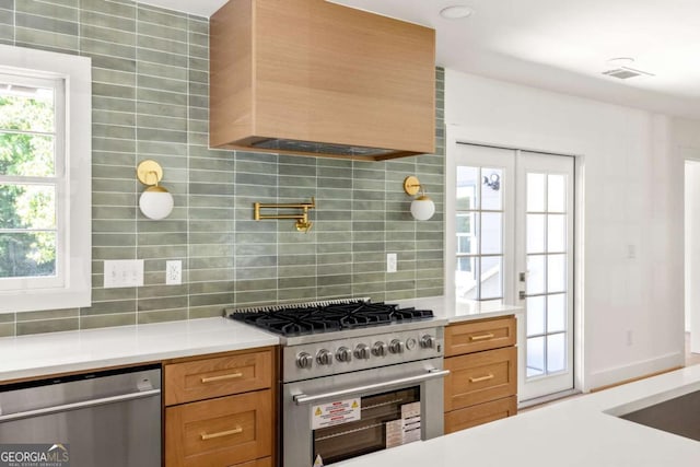 762 Rockbridge Rd NW, Lilburn, GA 30047 - kitchen featuring appliances with stainless steel finishes, tasteful backsplash, custom range hood, light countertops, and brown cabinetry