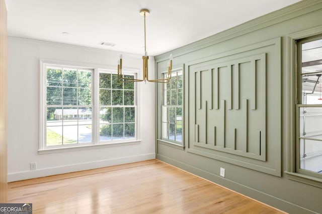 762 Rockbridge Rd NW, Lilburn, GA 30047 - unfurnished dining area with baseboards, wood finished floors, a chandelier, and ornamental molding