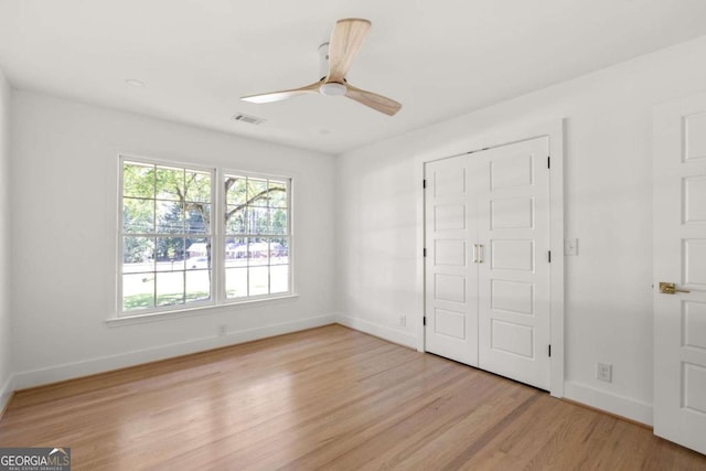 762 Rockbridge Rd NW, Lilburn, GA 30047 - unfurnished bedroom with multiple windows, baseboards, light wood-type flooring, and ceiling fan