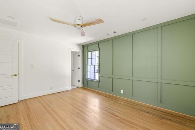 762 Rockbridge Rd NW, Lilburn, GA 30047 - unfurnished room with a decorative wall, light wood-style floors, a ceiling fan, and baseboards