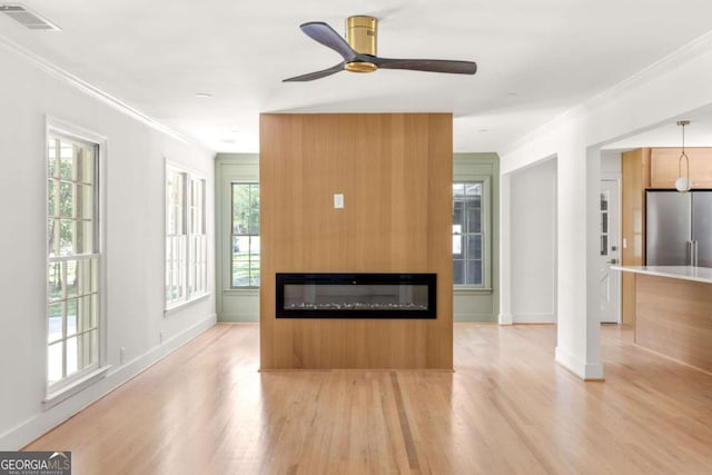 762 Rockbridge Rd NW, Lilburn, GA 30047 - unfurnished living room featuring crown molding, light wood-style flooring, a glass covered fireplace, a ceiling fan, and baseboards