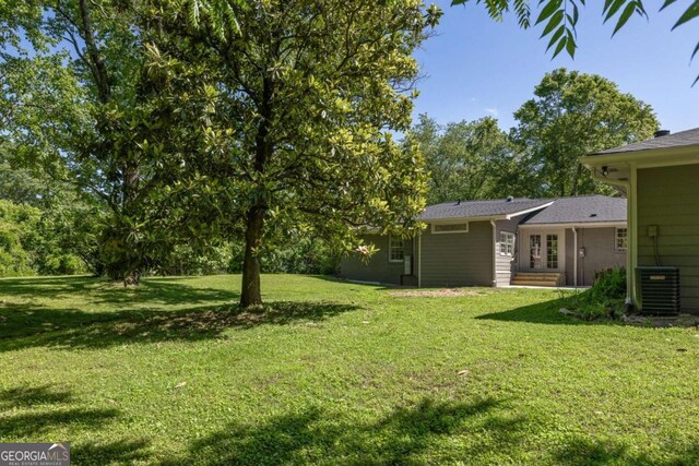 762 Rockbridge Rd NW, Lilburn, GA 30047 - view of green lawn featuring central air condition unit and french doors