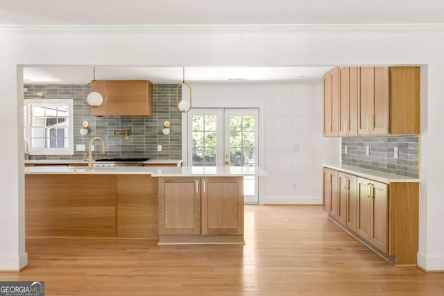 762 Rockbridge Rd NW, Lilburn, GA 30047 - kitchen with tasteful backsplash, light countertops, light wood-style floors, baseboards, and crown molding
