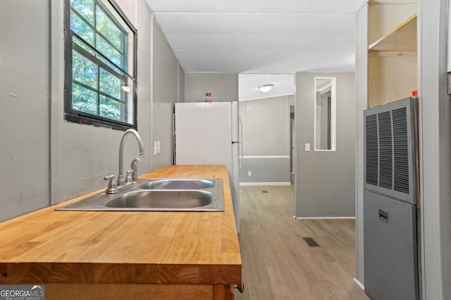 236 Overland Trl, Sparta, GA 31087 - kitchen featuring a heating unit, a sink, light wood-style floors, freestanding refrigerator, and wood counters