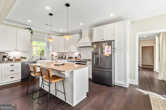 90 Middle St, Senoia, GA 30276 - kitchen featuring stainless steel appliances, premium range hood, a sink, white cabinets, and a breakfast bar area