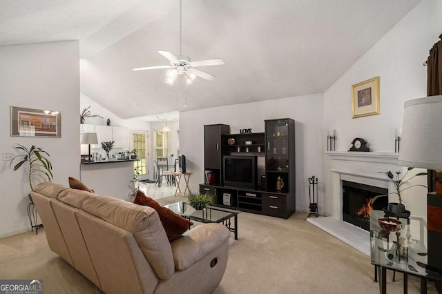 4378 Chestnut Oaks Trce, Lithonia, GA 30038 - living room featuring vaulted ceiling, light colored carpet, ceiling fan, a warm lit fireplace, and baseboards