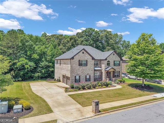271 Learwood, Atlanta, GA 30349 - view of front facade featuring an attached garage, driveway, a front lawn, and brick siding