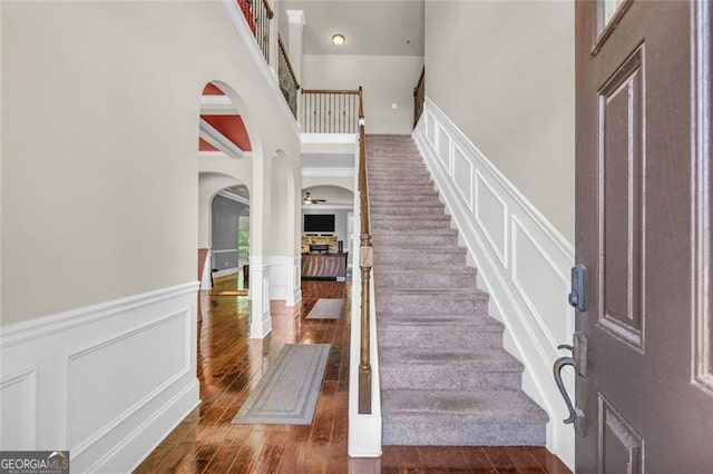 271 Learwood, Atlanta, GA 30349 - foyer entrance with arched walkways, a wainscoted wall, stairs, a towering ceiling, and hardwood / wood-style floors