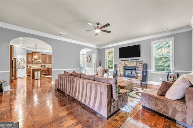 271 Learwood, Atlanta, GA 30349 - living area with arched walkways, a fireplace, ceiling fan, dark wood finished floors, and ornamental molding