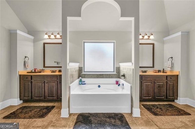 271 Learwood, Atlanta, GA 30349 - bathroom featuring lofted ceiling, tile patterned floors, a bath, two vanities, and baseboards