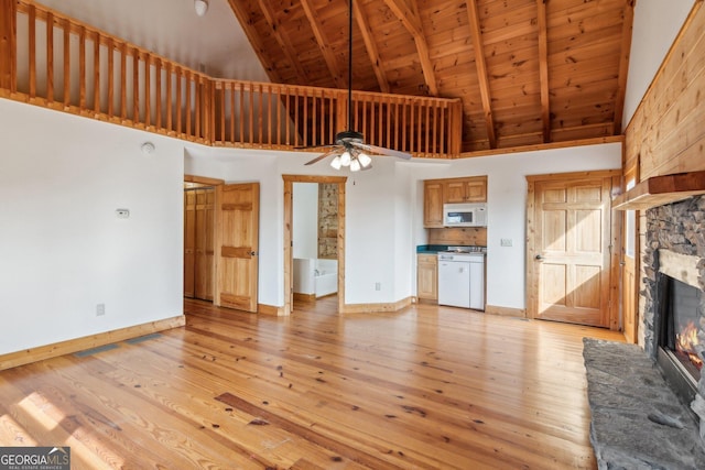 435 Ranch Mountan Dr, Dahlonega, GA 30533 - unfurnished living room with high vaulted ceiling, a stone fireplace, baseboards, a ceiling fan, and wooden ceiling with exposed beams