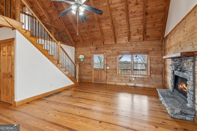435 Ranch Mountan Dr, Dahlonega, GA 30533 - unfurnished living room with wooden ceiling with exposed beams, light wood-type flooring, high vaulted ceiling, a fireplace, and baseboards
