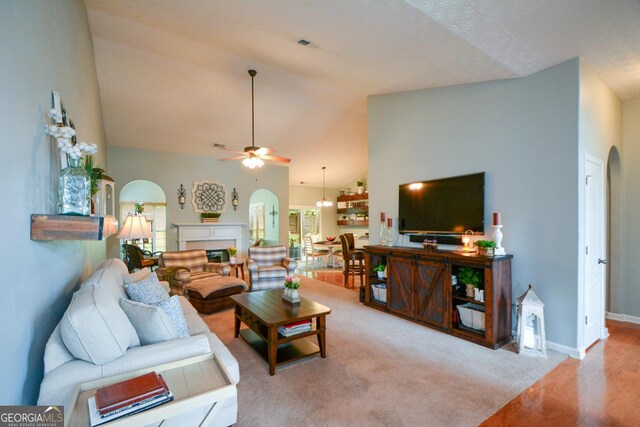 9013 Aldbury Dr, Locust Grove, GA 30248 - living area with arched walkways, a ceiling fan, a fireplace, high vaulted ceiling, and wood finished floors