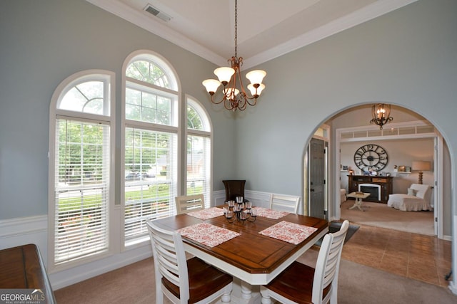 9013 Aldbury Dr, Locust Grove, GA 30248 - dining area with arched walkways, carpet floors, a chandelier, a towering ceiling, and a wainscoted wall