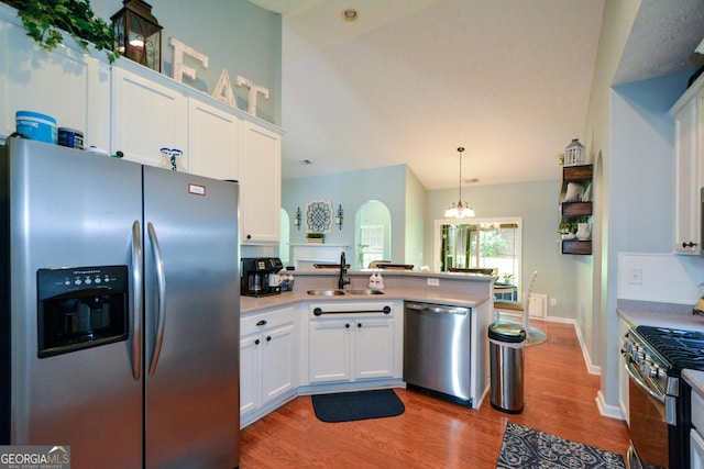9013 Aldbury Dr, Locust Grove, GA 30248 - kitchen featuring appliances with stainless steel finishes, a sink, light wood-style floors, a peninsula, and white cabinetry
