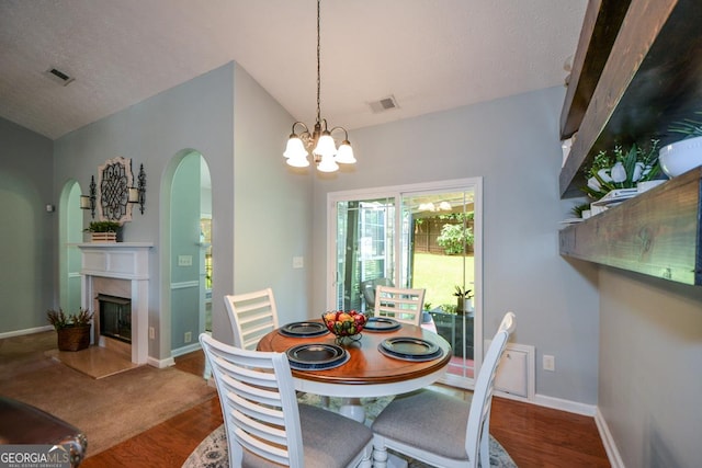 9013 Aldbury Dr, Locust Grove, GA 30248 - dining area with arched walkways, a chandelier, a fireplace, lofted ceiling, and a textured ceiling