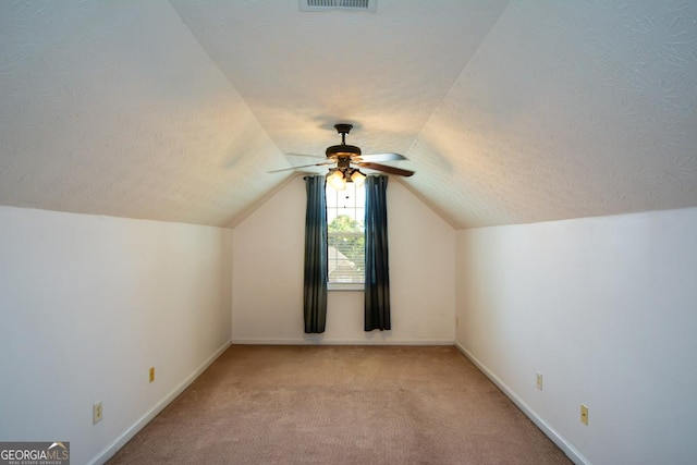 9013 Aldbury Dr, Locust Grove, GA 30248 - additional living space featuring light carpet, a textured ceiling, vaulted ceiling, baseboards, and a ceiling fan