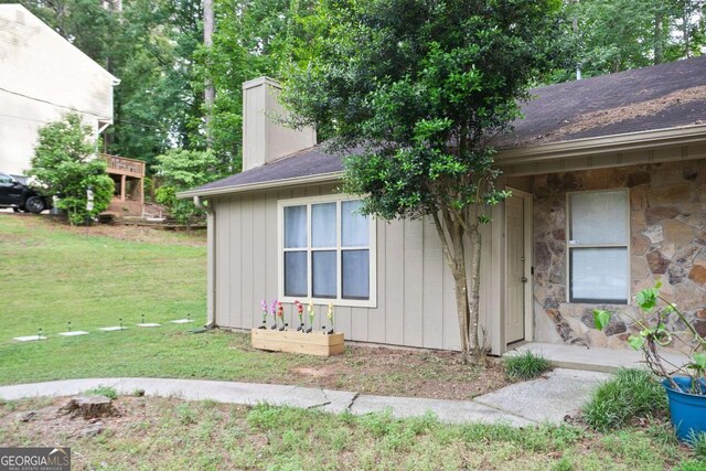 189 Timber Creek Ln, Marietta, GA 30060 - view of side of property featuring a chimney, a lawn, stone siding, and a shingled roof