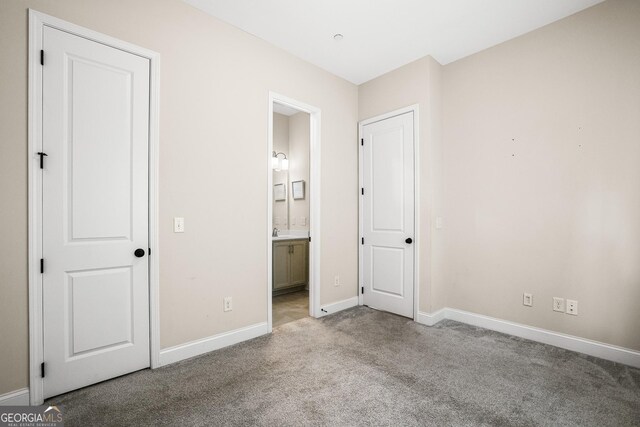 1058 Kirkland Cir, Smyrna, GA 30080 - unfurnished bedroom featuring carpet flooring, baseboards, ensuite bathroom, and a sink