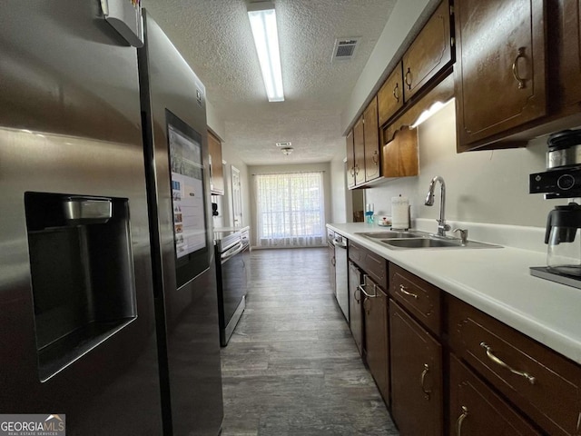 43 Fabian Ln, Hinesville, GA 31313 - kitchen with stainless steel appliances, a sink, a textured ceiling, light countertops, and dark wood-style flooring