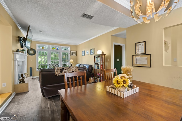 220 Renaissance Pkwy Unit 1115, Atlanta, GA 30308 - dining room featuring crown molding, a chandelier, wood finished floors, and a textured ceiling