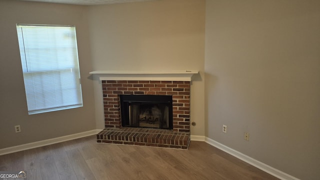 6120 Raleigh Oaks Ct, Lithonia, GA 30058 - unfurnished living room featuring wood finished floors, baseboards, and a brick fireplace