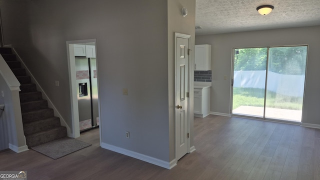 6120 Raleigh Oaks Ct, Lithonia, GA 30058 - unfurnished living room with wood finished floors, baseboards, stairway, and a textured ceiling