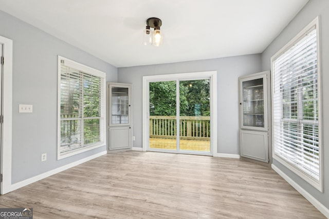 6072 Holiday Blvd, Forest Park, GA 30297 - unfurnished dining area with healthy amount of natural light, light wood-style flooring, and baseboards