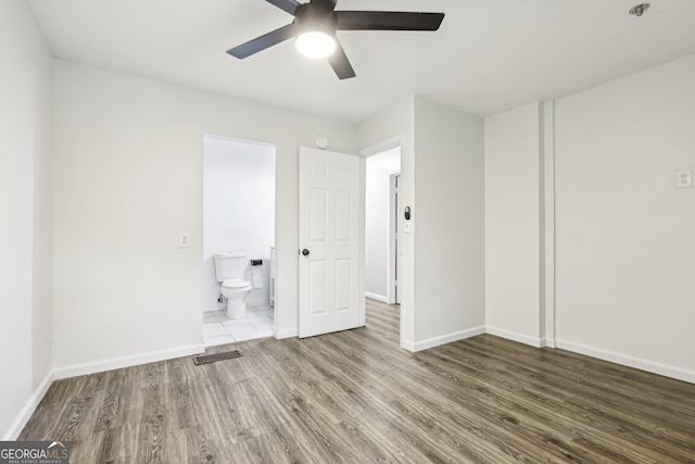 6072 Holiday Blvd, Forest Park, GA 30297 - unfurnished bedroom with wood finished floors, baseboards, and ensuite bath