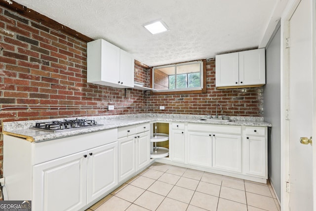 6072 Holiday Blvd, Forest Park, GA 30297 - kitchen with a sink, a textured ceiling, light tile patterned floors, white cabinetry, and stainless steel gas stovetop