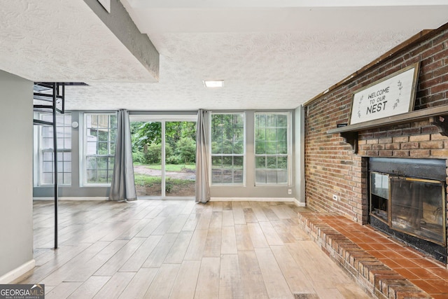 6072 Holiday Blvd, Forest Park, GA 30297 - unfurnished living room with baseboards, wood finished floors, a fireplace, and a textured ceiling