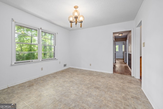 136 Briarwood Dr, Toccoa, GA 30577 - empty room featuring a chandelier, plenty of natural light, a textured ceiling, and baseboards