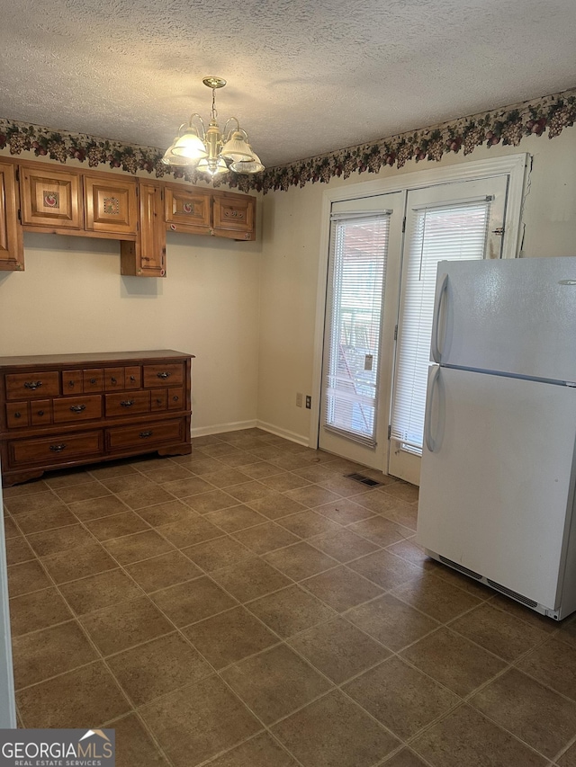 421 Chase Cir, Cornelia, GA 30531 - unfurnished dining area with a chandelier, dark tile patterned floors, a textured ceiling, and baseboards