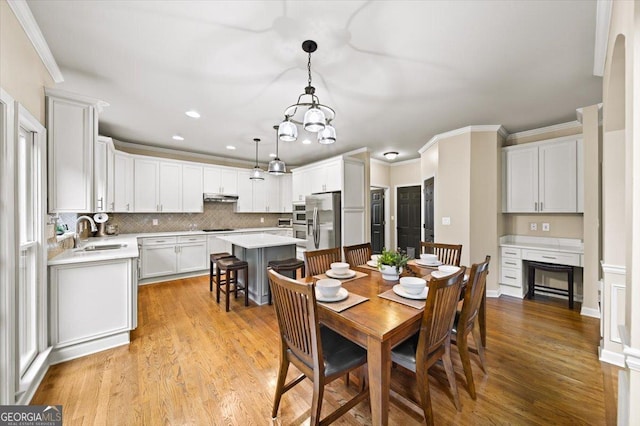 161 Highgrove Dr, Suwanee, GA 30024 - dining room featuring light wood-type flooring, recessed lighting, crown molding, a chandelier, and a fireplace