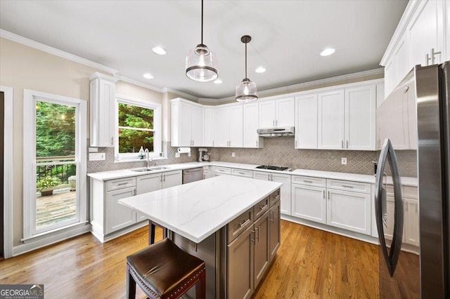 161 Highgrove Dr, Suwanee, GA 30024 - kitchen featuring appliances with stainless steel finishes, a sink, under cabinet range hood, crown molding, and white cabinetry