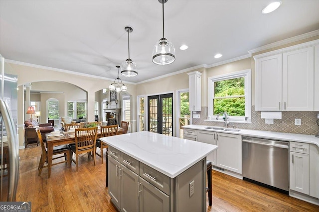 161 Highgrove Dr, Suwanee, GA 30024 - kitchen featuring stainless steel appliances, a sink, decorative columns, arched walkways, and french doors